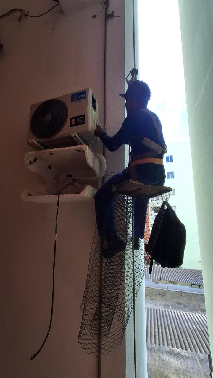 Técnico da RJB instalando condensadora em altura
